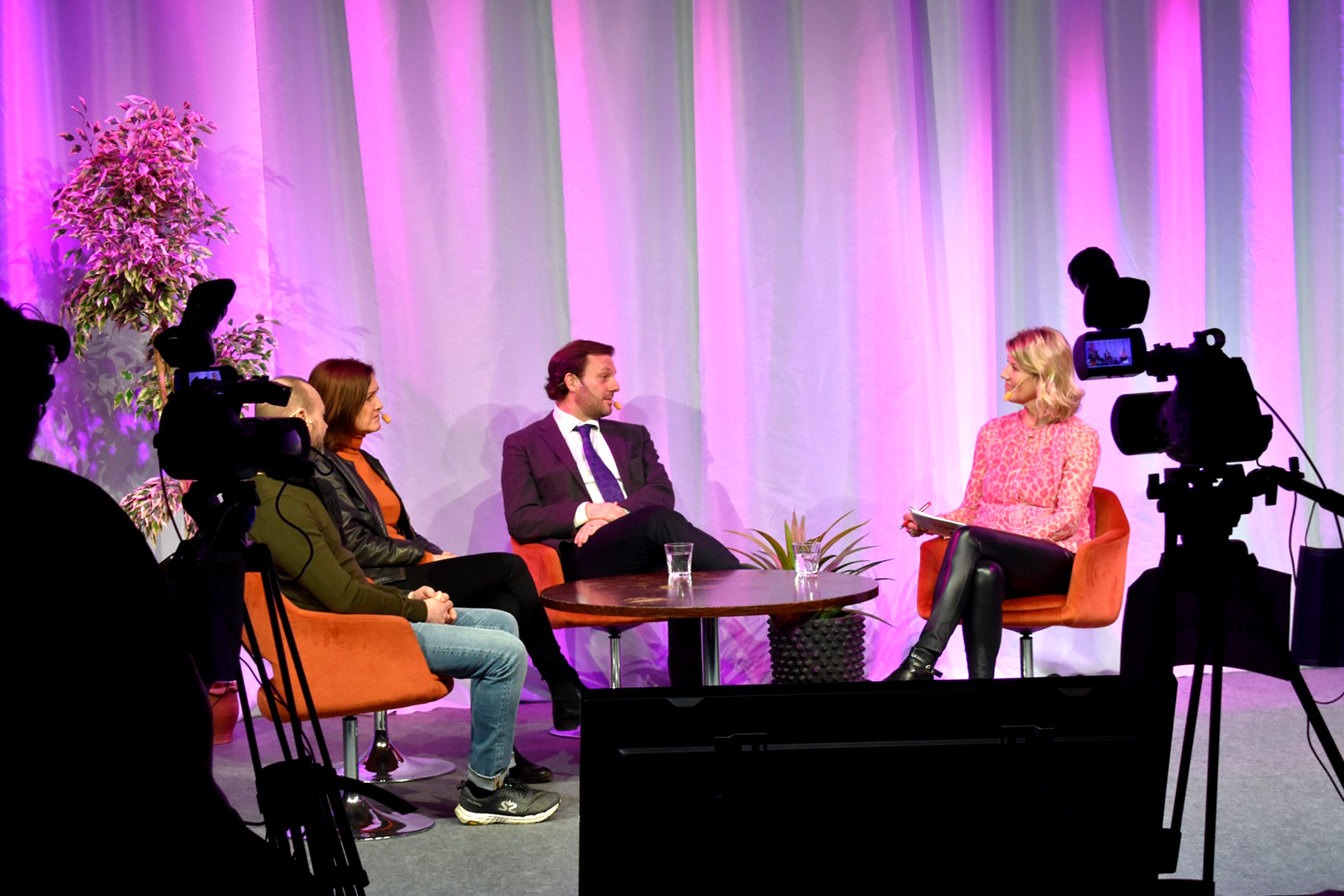 Konferencier Pernilla warberg i filmstudio samtalandes med en panel