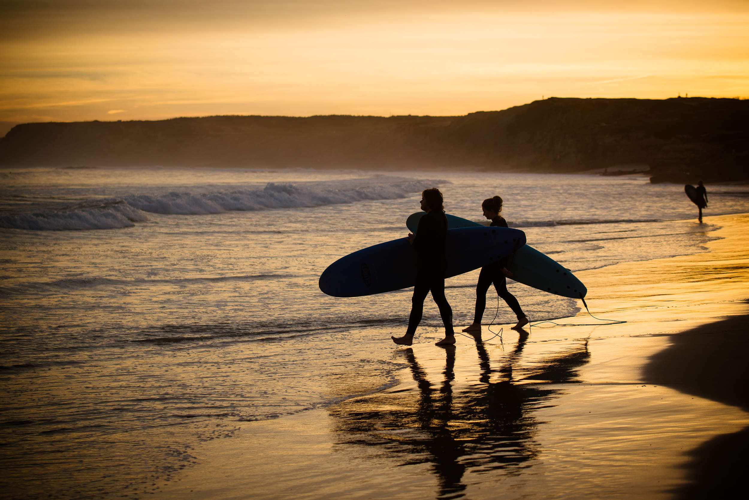 Tavla på surfare i soluppgång