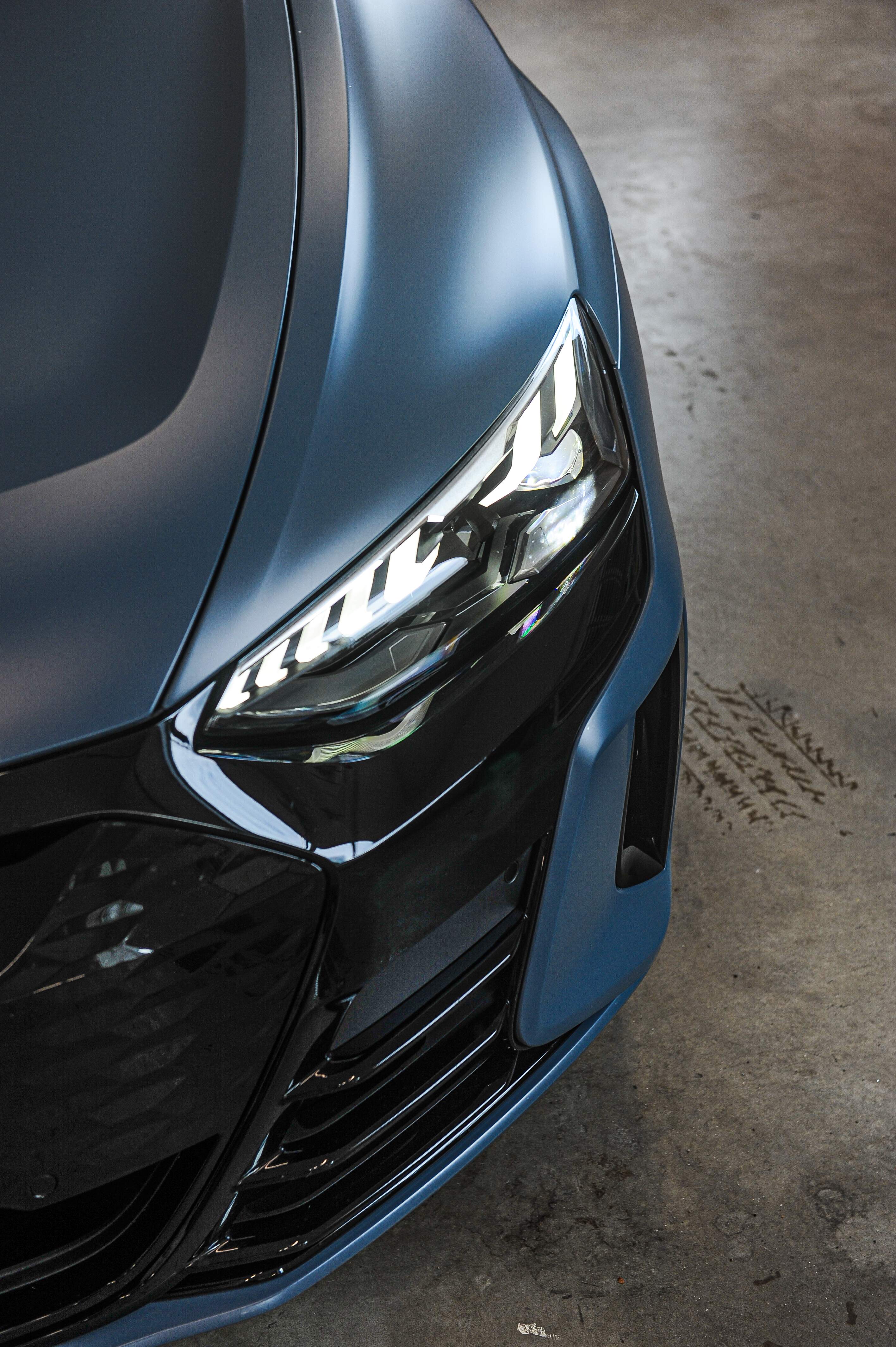 Detaljbild på front av en folierad Audi etron GT.