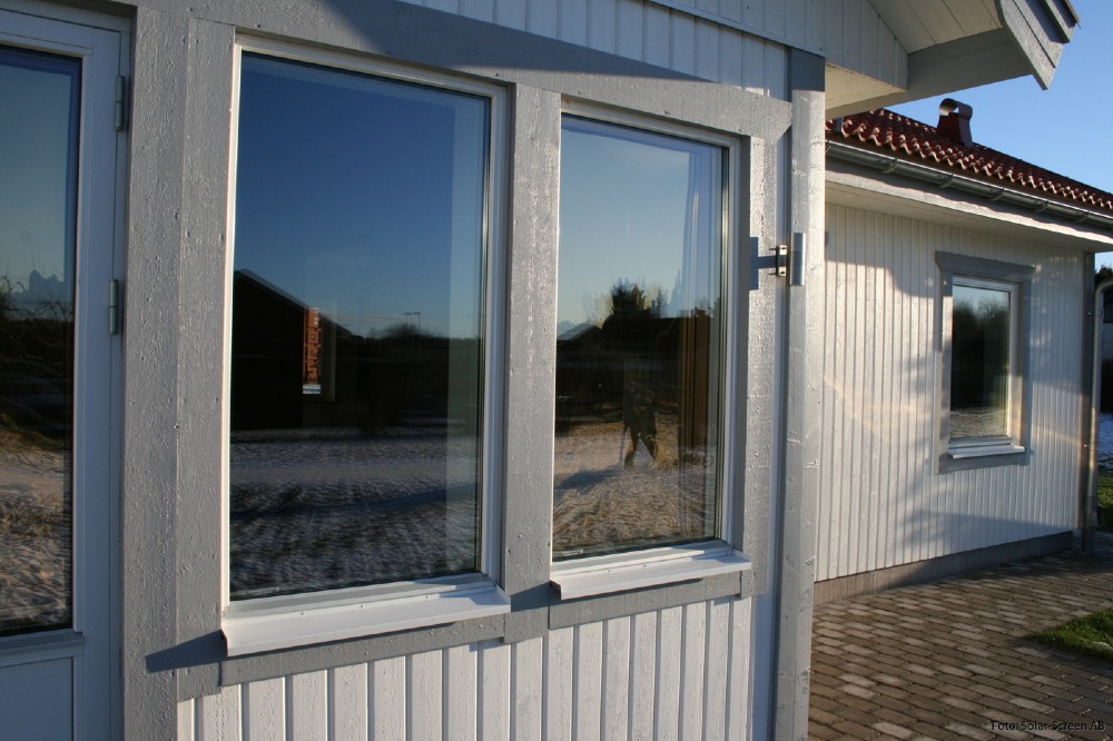 Solskyddsrullgardiner i en villas fönster