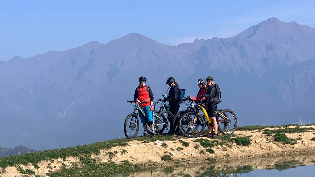 Fyra MTB cyklister väntar på andra sidan sjön